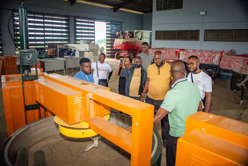 An image showing Niji Garri fryer anf visitors at the company's workshop.
